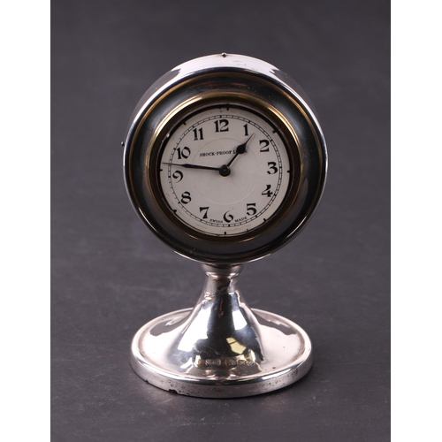 1131 - An early 20th century silver dressing table clock, the white dial with Arabic numerals, 7cms diamete... 