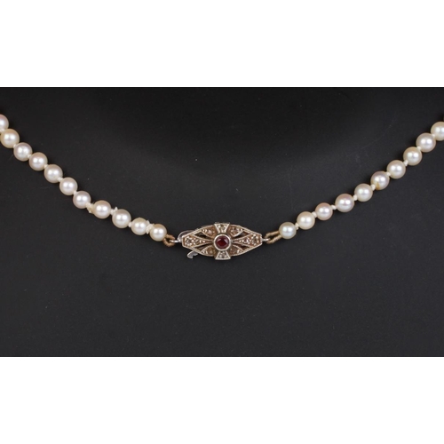 1225 - A Cropp & Farr graduated cultured pearl necklace with 9ct white gold clasp set with a central ruby a... 