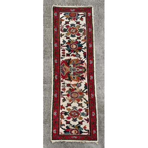 1371 - A Caucasian runner having a repeating floral design on a cream ground within a red and repeating geo... 