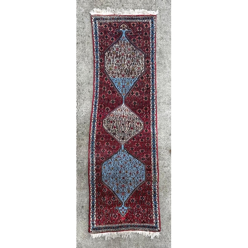 1372 - A Caucasian runner, decorated repeating floral guls on a red and floral ground, within a multi borde... 