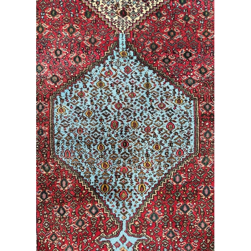 1372 - A Caucasian runner, decorated repeating floral guls on a red and floral ground, within a multi borde... 