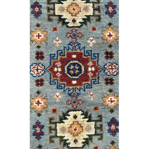 1373 - A Persian runner, having repeating geometric motifs on a blue ground within a maroon geometric borde... 