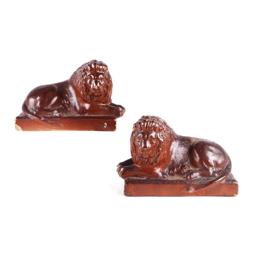 1398 - A pair of early Victorian stoneware models of recumbent lions, 15cms wide.