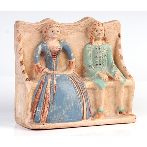 1403 - A flat back pottery group depicting an Elizabethan couple seated on a settle, possibly Compton Potte... 