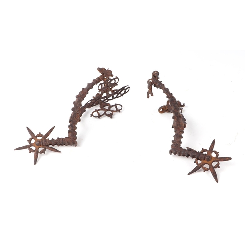 1454 - A pair of 17th century steel Rowel spurs of ornate design, probably English, 16cms long.