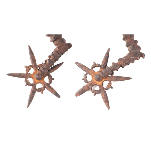 1454 - A pair of 17th century steel Rowel spurs of ornate design, probably English, 16cms long.