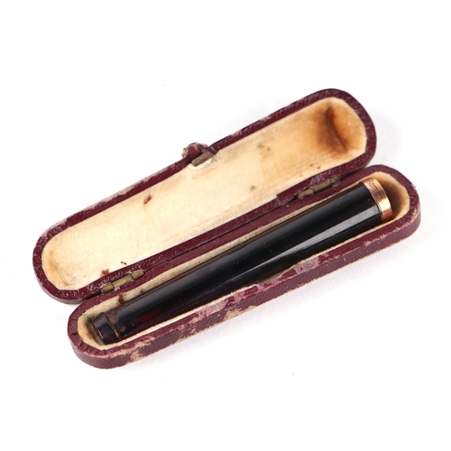 1562 - A cherry amber type cheroot holder with 9ct gold collar, cased.