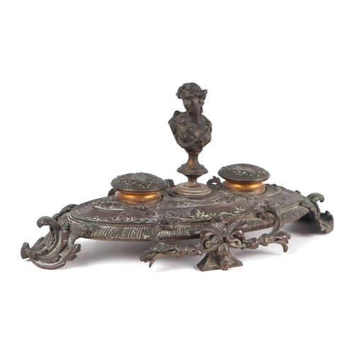 1577 - A 19th century French brass double inkwell with the bust of a lady to the centre, 32cms wide.