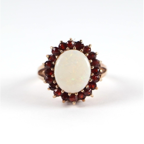 1824 - A 9ct gold opal and garnet cluster ring with central opal surrounded by a halo of garnets, approx UK... 