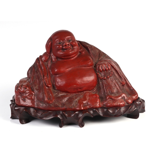 1962 - A large Chinese cinnabar lacquer buddha mounted on a hardwood stand, 27cm wide