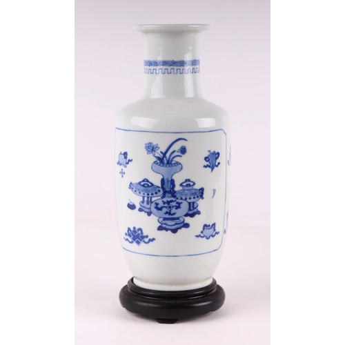 1971 - A Chinese blue and white rouleau vase decorated with a river landscape and precious objects, on a ha... 