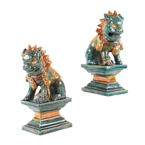 1981 - A pair of Chinese glazed temple lions seated on plinths, 16cms high (2).