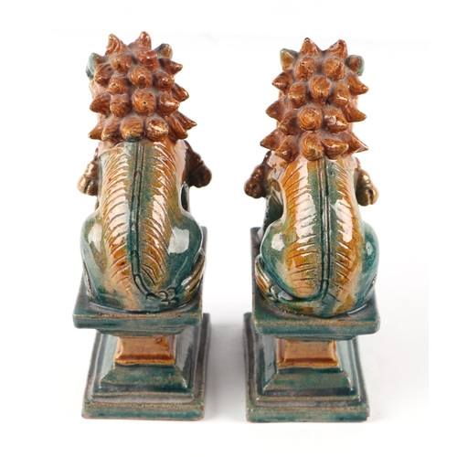 1981 - A pair of Chinese glazed temple lions seated on plinths, 16cms high (2).