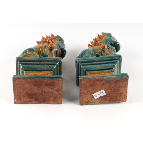 1981 - A pair of Chinese glazed temple lions seated on plinths, 16cms high (2).