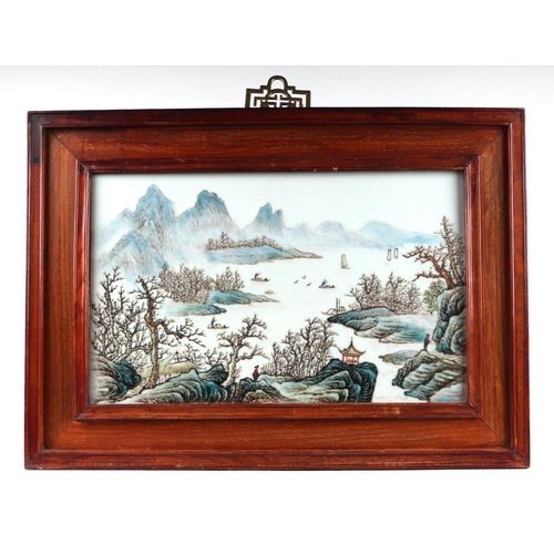 1989 - A Chinese rectangular porcelain plaque depicting a river landscape scene, framed, 42 by 26cms.