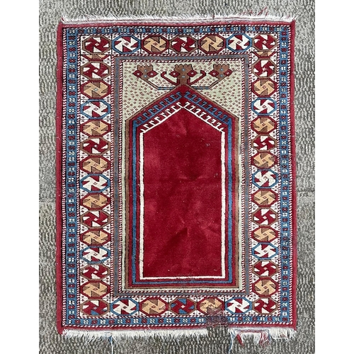 1995 - A Persian prayer rug, having a central motif on a maroon ground within a multi geometric border, 115... 