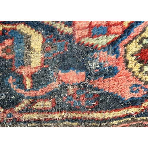 1998 - A large Persian Heriz rug with geometric design, on a rust ground, 290 by 356cms.