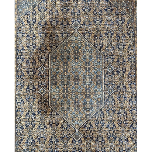 1999 - A Keshan rug with repeated geometric design on a beige ground. 250 by 344cm