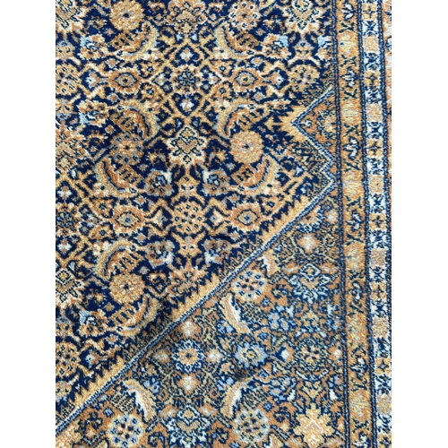 1999 - A Keshan rug with repeated geometric design on a beige ground. 250 by 344cm