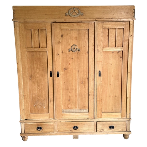 2002 - A Continental pine triple wardrobe with three drawers to the base and fitted interior, 164cm wide