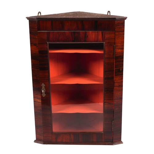 2022 - A rosewood corner cupboard, the single glazed door enclosing a shelved interior, 51cms wide.