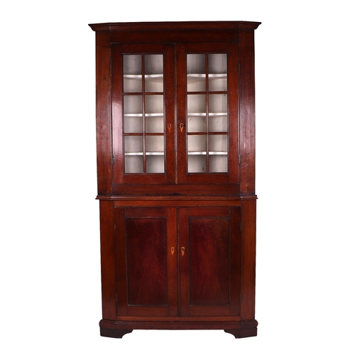 2063 - A 19th century oak corner glazed display cabinet on cupboard, the moulded cornice above twin paned g... 