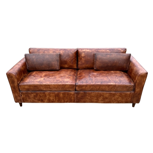 2067 - A modern design distressed brown leather three seater sofa, 206cms wide.