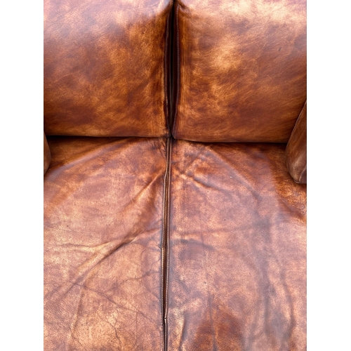 2067 - A modern design distressed brown leather three seater sofa, 206cms wide.