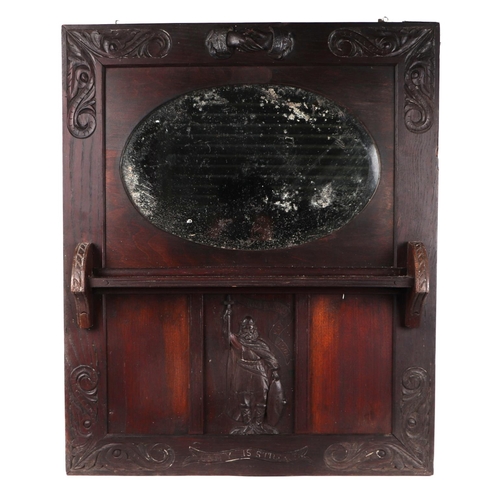 2084 - An early 20th century carved oak framed mirror with oval plate, carved with clasped hands above and ... 