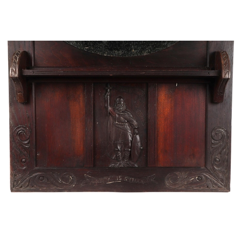 2084 - An early 20th century carved oak framed mirror with oval plate, carved with clasped hands above and ... 