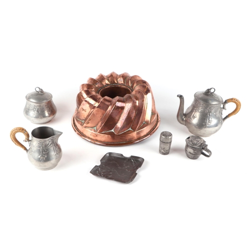 256 - A Victorian copper jelly mould, 24cms diameter; together with a Liberty & Co. part pewter cruet set ... 