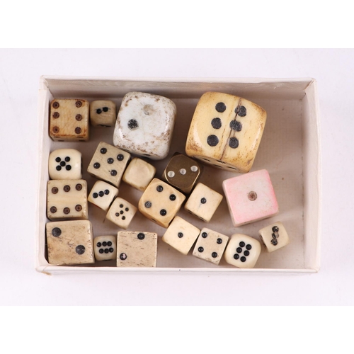 258 - A collection of antique gaming items, including dice, brass gambling tokens, two dice shakers togeth... 