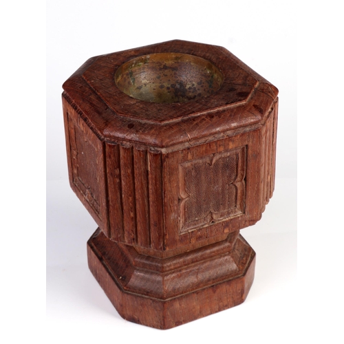 303 - A 19th century carved oak travelling font with brass liner, 23cm high