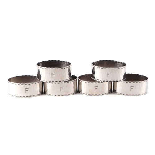 383 - A set of six Keswick School of Industrial Arts hammered Staybrite steel napkin rings, initialled 'F'... 