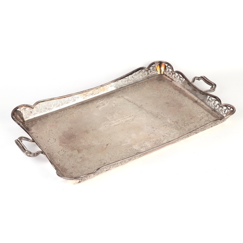 425 - A silver two-handled tray with pierced gallery and engraved with foliate scrolls, having a presentat... 