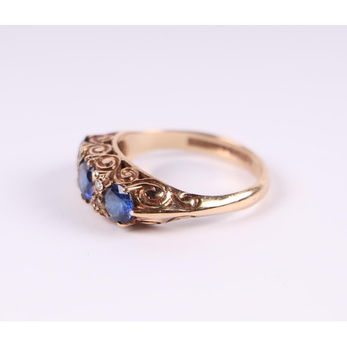 462 - A 9ct gold ring set with three large sapphires interspersed with diamonds, approx UK size 'M'.