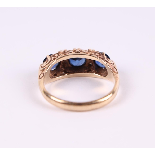 462 - A 9ct gold ring set with three large sapphires interspersed with diamonds, approx UK size 'M'.