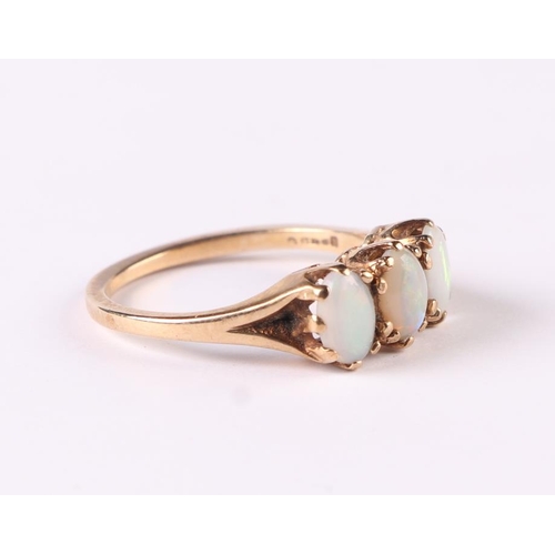 507 - A 9ct gold three-stone opal ring, approx UK size 'M', 2.4g.