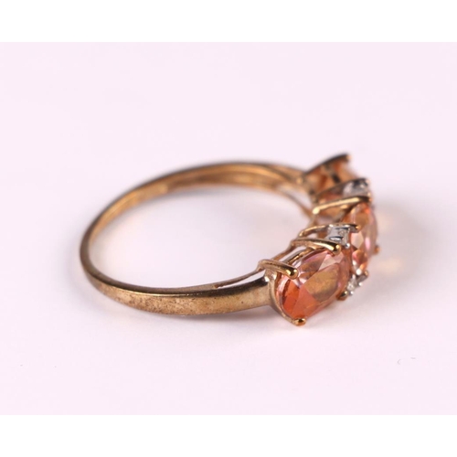 514 - A 9ct gold dress ring set with three pink stones interspersed with diamond,s approx UK size 'P', 2g.