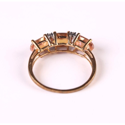 514 - A 9ct gold dress ring set with three pink stones interspersed with diamond,s approx UK size 'P', 2g.