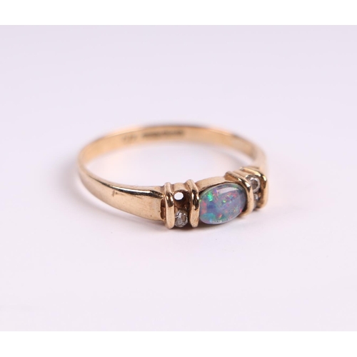 522 - A 9ct gold ring set with a central opal flanked by cubic zirconia, approx UK size 'O', 1.8g.Conditio... 