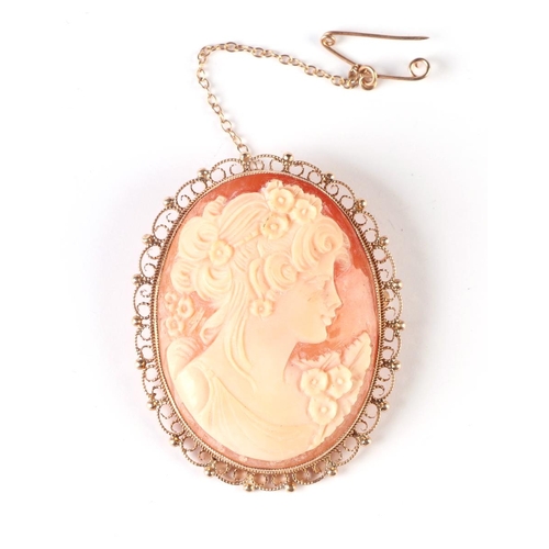 563 - A 9ct gold mounted cameo brooch with safety chain, 3.5 by 4.5cms, total weight 11.5g.