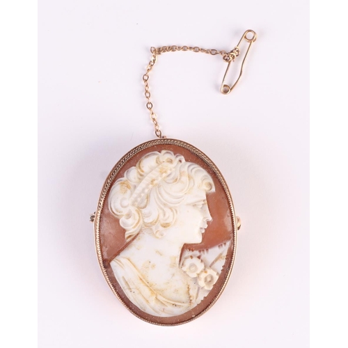 565 - A 9ct gold mounted cameo brooch with safety chain, 3 by 4cms, 12.9g.