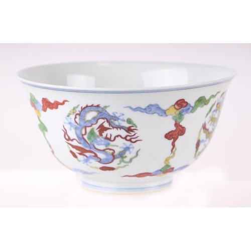 612 - A Chinese Wucai style footed bowl decorated with dragons amongst clouds, six character blue mark to ... 