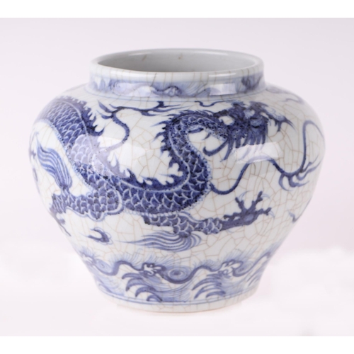 613 - A Chinese blue & white crackleware vase decorated with a dragon amongst clouds, 20cms high.