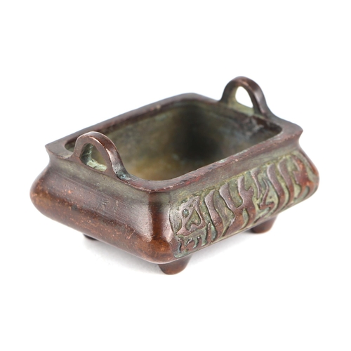 623 - A Chinese bronze censer of small proportion with cast decoration, four squat feet and character mark... 