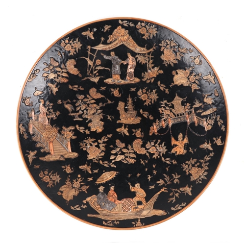 647 - A large Chinese famille noir charger decorated with figures, flowers and butterflies on a black grou... 