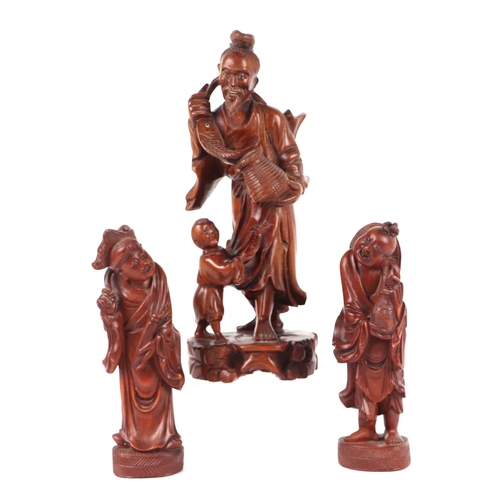 649 - A Chinese hardwood group depicting a fisherman and young boy, 26cms high; together with two similar ... 