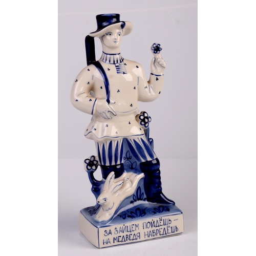 72 - A Russian porcelain blue and white figural candlestick in the form of a hunter carrying his rifle, 2... 