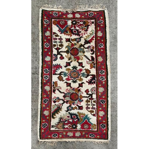 733 - A Caucasian rug having a repeating floral motifs on a cream ground within a red and floral border, 1... 